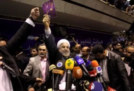 Iranian presidential candidate Hasan Rouhani, center, holds up a leaflet showing a key, the symbol of his campaign, during a rally in Tehran, Iran, Saturday, June 8, 2013.