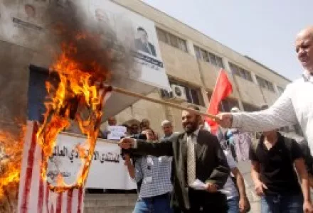 Activists from the Jordan Professional Associations on Thursday May 14, 2009, burn flags during a protest against the meeting of the World Economic Forum.