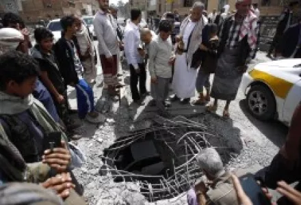 People stand around damages made by a Saudi-led airstrike on a bridge in Sanaa, Yemen, Wednesday, March 23, 2016.