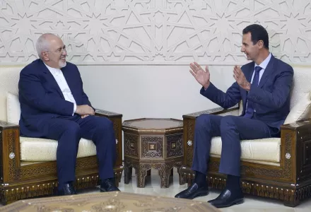 In this photo released by the Syrian official news agency SANA, Syrian President Bashar Assad, right, speaks with Iranian Foreign Minister Mohammad Javad Zarif in Damascus, Syria, Monday, Sept 3, 2018. 
