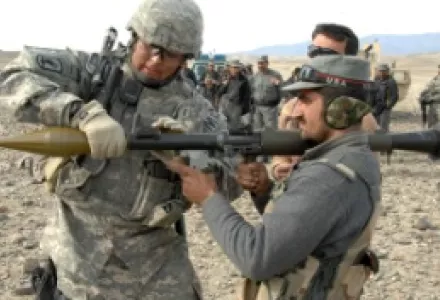 A U.S. Army soldier coaches an Afghan National Police officer as he prepares to fire a rocket-propelled grenade launcher during a skills assessment mission on a range in Beshud, Afghanistan, Feb. 13, 2008.