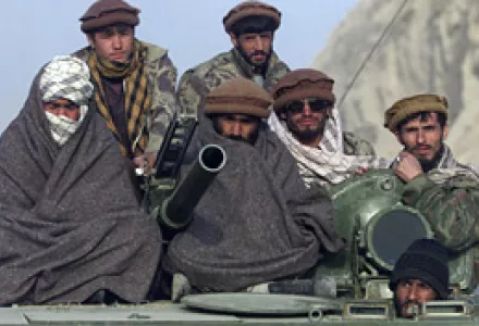 Northern alliance soldiers ride on a tank as they prepare to enter the town of Khanabad, northern Afghanistan