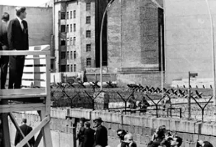 U.S. President John F. Kennedy stands on an observation platform near Checkpoint Charlie to look over the Berlin Wall towards East Berlin, June 26, 1963.