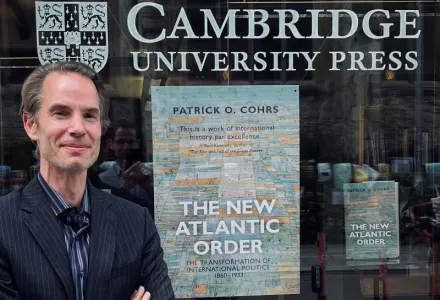 Patrick Cohrs poses in front of a bookstore display of The New Atlantic Order