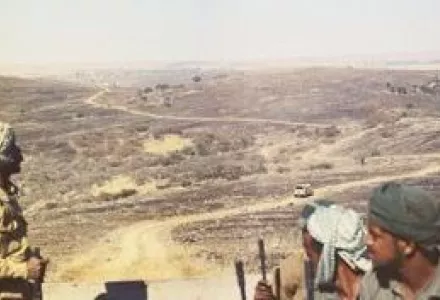 Troops traverse the Midway Road through Dhofar's desolate terrain in 1974. This track, the only built-up road in the Omani province at the time, was the lone land link to northern Oman.