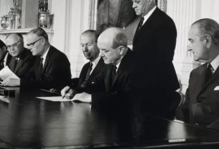 President Lyndon Johnson looking on as Secretary of State Dean Rusk prepares to sign the NPT, 1 July 1968.