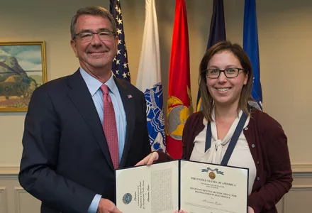 Sasha Baker receives the Department of Defense medal for distinguished public service from Ash Carter.