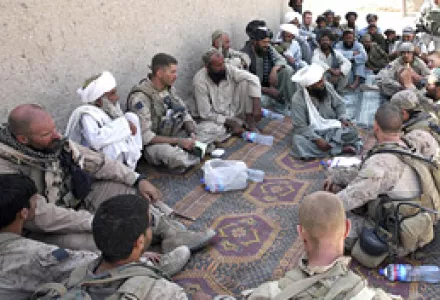 Afghan army officers and U.S. Marines take part in a shura meeting to discuss damage done during an Aug. 12 raid to a family compound in Dahaneh, Afghanistan, Aug. 14, 2009. Compensation was paid, part of a U.S. effort to win "hearts and minds."