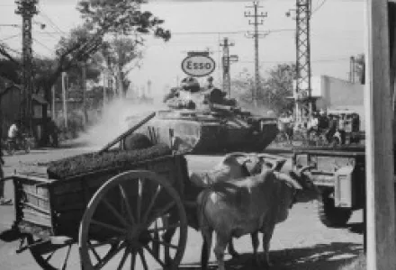 Tank from 1st Battalion, 69th Armor, 25th Infantry Division, moves through Saigon shortly after disembarking from a Landing Ship, Tank at Saigon Harbor, 3/12/1966.