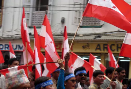 Demonstrators wave flags and chant in Nepalese, near the Thamel shopping area of Kathmandu, Nepal. There was no violence at this point but off image (behind the camera) there is a heavy military/police presence, 1 Apr. 2004.   Later in the day, low degree violence took place involving the police/military and protesters.