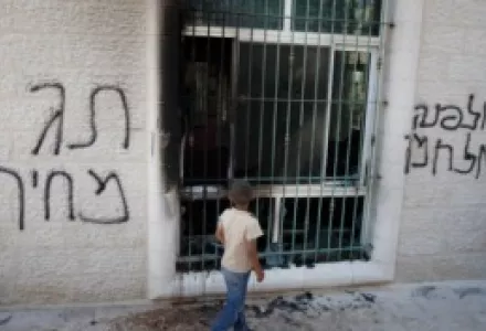 A Palestinian child stands outside a vandalized mosque in the West Bank town of Jabaa, June 19, 2012. Acts of vandalism against Palestinian property are perpetrated by radical settlers in retaliation for government settlement policy that they oppose.
