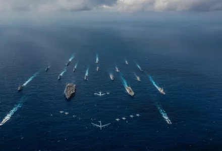 The aircraft carrier USS Ronald Reagan (CVN 76), left, and the Japan Maritime Self-Defense Force helicopter destroyer JS Hyuga (DDH 181), right, sail in formation with 16 other ships from the U.S. Navy and the Japan Maritime Self-Defense Force as aircraft from the U.S. Air Force and Japan Air Self-Defense Force fly overhead in formation during Keen Sword 2019.