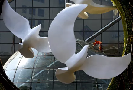 A worker cleans glass panels of the Bank of China headquarters building near a decoration setup for the Forum on China-Africa Cooperation (FOCAC) in Beijing, Sunday, Aug. 26, 2018. Chinese President Xi Jinping will chair the forum held in the capital city from Sept. 3-4, 2023.