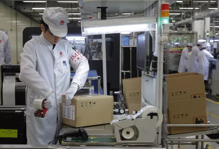 A staff member works on a mobile phone production line during a media tour of a Huawei factory in Dongguan, Guangdong, Wednesday, March 6, 2019.