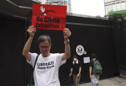 A protester holds up a placard outside the U.S. Consulate in Hong Kong, Wednesday, June 26, 2019.
