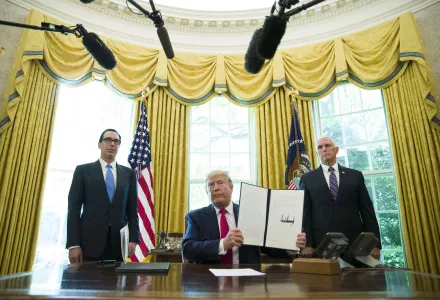 In this June 24, 2019, file photo, President Donald Trump holds up a signed executive order to increase sanctions on Iran, in the Oval Office of the White House in Washington, with Treasury Secretary Steven Mnuchin, left, and Vice President Mike Pence.