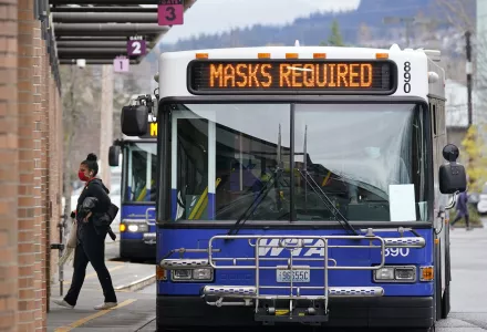 Photo of a mask-wearing passenger departs a bus where masks are required of riders Tuesday, Nov. 17, 2020, in Bellingham, Wash. 