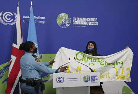 Photo of a member of security moving to apprehend a demonstrator at the COP26 U.N. Climate Summit in Glasgow, Scotland, Saturday, Nov. 13, 2021.