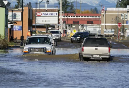 Trucks drive through floodwaters at the U.S.-Canada border crossing in Sumas, Washington. 