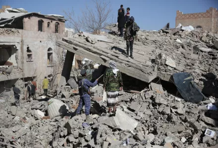 People inspect the wreckage of buildings that were damaged by Saudi-led coalition airstrikes, in Sanaa, Yemen, Tuesday, Jan. 18, 2022.