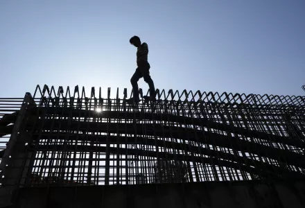 An Indian laborer works to construct a flyover in Jammu, India