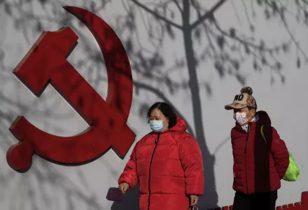 Residents wearing face masks walk by tree shadow cast on a Communist Party's logo near a residential area in Beijing, Thursday, March 2, 2023. Chinese leader Xi Jinping's agenda for the annual meeting of the ceremonial legislature: Revive the economy by encouraging consumers to spend more now that severe anti-virus controls have ended, and install a government of loyalists to intensify Communist Party control over the economy and society. (AP Photo/Andy Wong)