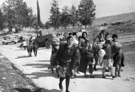 Armed with a double-barrelled shotgun, a young Turkish Cypriot leads women and children from the village of Ayios Sozomenos to another nearby large Turkish village following a gun battle between Greeks and Turks on Feb. 6, 1964.