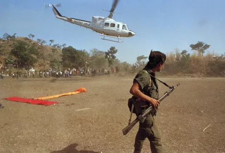 A leftist combatant of the FMLN stands guard as a U.N. helicopter lands carrying guerrilla commanders in San Jose Las Flores, Jan. 22, 1992.