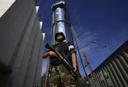 A soldier guards a transport cask containing a transfer cylinder that holds highly enriched uranium at "La Reina" reactor in Santiago, Chile on February 18, 2010. (AP Photo/Jorge Saenz)