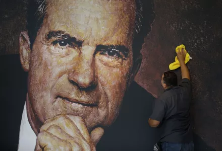 In this Wednesday, Oct. 5, 2016 photo, Tayron Santos cleans the newly-installed wall mural of former President Richard Nixon in the lobby area of the Richard Nixon Presidential Library and Museum in Yorba Linda, Calif. The museum will reopen Friday, Oct. 14, following a $15 million makeover aimed at bringing the country’s 37th president closer to younger generations less familiar with his groundbreaking trip to China or the Watergate scandal. (AP Photo/Jae C. Hong)