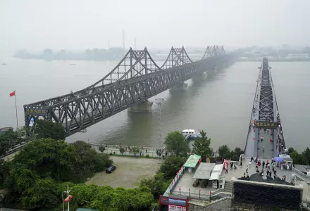 Visitors walk across the Yalu River Broken Bridge, right, next to the Friendship Bridge connecting China and North Korea in Dandong in northeastern China's Liaoning province.