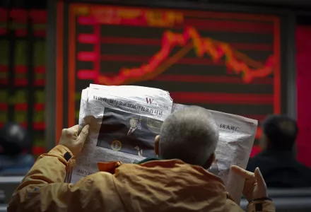 A man reads a newspaper at a brokerage house in Beijing.