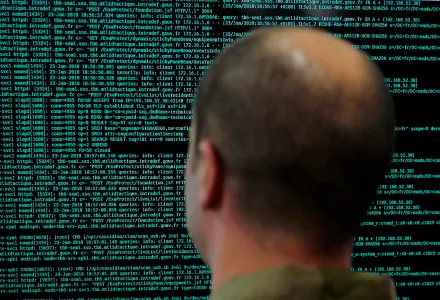 A soldier watches code lines on his computer screen at the French Defense ministry stand during the International Cybersecurity forum in Lille, northern France.