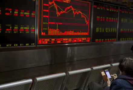 An investor monitors stock prices in Beijing after U.S. President Donald Trump re-imposes sanctions on Iran, May 19, 2018.