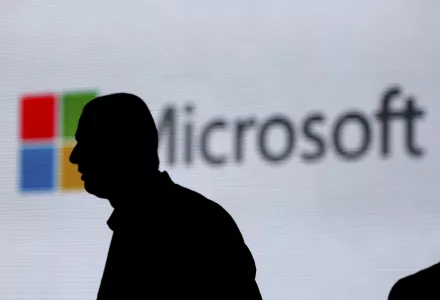 In this Nov. 7, 2017, file photo, an unidentified man is silhouetted as he walks in front of Microsoft logo at an event in New Delhi, India. Microsoft says it's committing to giving users worldwide the same data and privacy rights being offered to Europeans under new regulations there. That means no matter where you live, you'll be able to see what Microsoft collects about you and correct or delete that information if necessary. 
