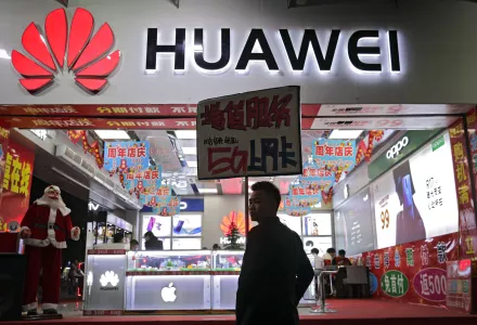 A worker holds a sign promoting a sale for Huawei 5G internet services at a mobile phones retail shop in Shenzhen in south China's Guangdong province, Tuesday, Dec. 18, 2018. The chairman of Huawei challenged the United States and other governments to provide evidence for claims the Chinese tech giant is a security risk as the company launched a public relations effort Tuesday to defuse fears that threaten its role in next-generation communications. 