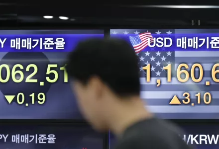 A currency trader stands by the screens showing the foreign exchange rates at the foreign exchange dealing room in Seoul, South Korea, Friday, Nov. 8, 2019. 