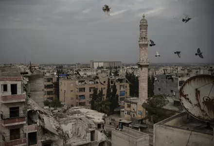 A mosque stands next to a a damaged building, in Idlib, Syria.