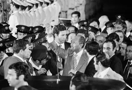 Egyptian President Anwar Sadat is surrounded by security people as he waves to cheering crowds just before he leaves Ben Gurion Airport for Jerusalem, Nov. 19, 1977.