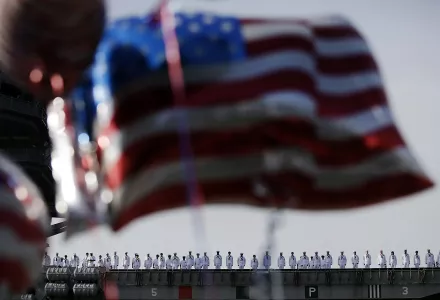 Sailors line up on U.S. navy nuclear-powered aircraft carrier USS Ronald Reagan as some U.S. flag-shaped balloons are hoisted to welcome them at the U.S. Navy's Yokosuka base in Yokosuka, south of Tokyo, October 1, 2015. (AP Photo/Eugene Hoshiko)