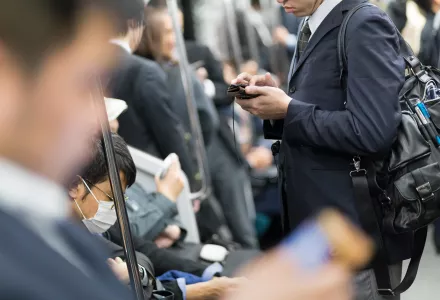 Commuters use mobile phones in Tokyo, Japan.