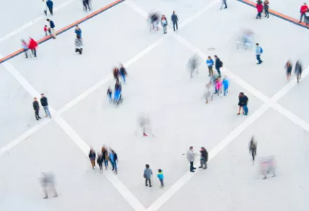 Blurred photo of people in a square from above.