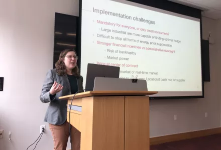Conleigh Byers speaks at a podium in front of a projector screen.