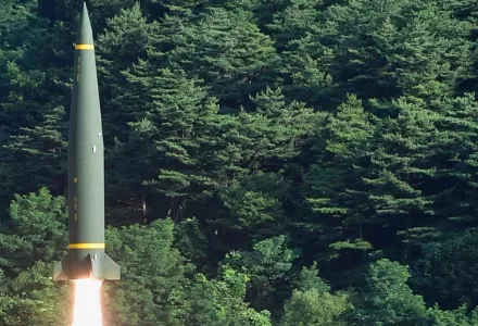 A North Korean missile launching against a forrest background.
