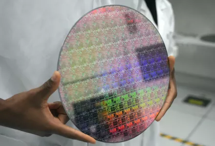Someone holds a silicon wafer with chips etched into it as Vice President Kamala Harris tours a site where Applied Materials plans to build a $4 billion research facility on Monday, May 22, 2023, in Sunnyvale, Calif. 