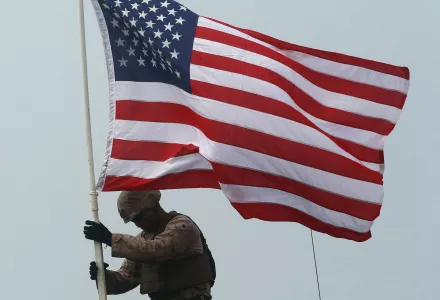 A U.S. Marine raising the American flag on an amphibious assault vehicle, Thailand, Saturday, February 17, 2018. 