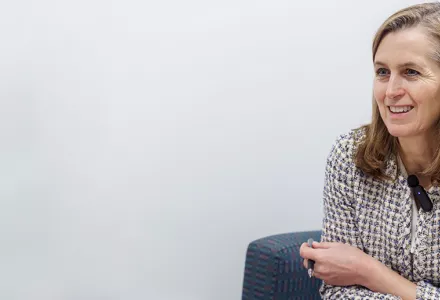 Catherine Wolfram sits on a blue chair.