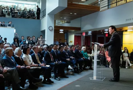 A wide shot of President Yoon at right on the stage in the JFK Jr Forum. At left, the audience.