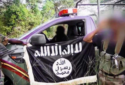 Al-Shabab fighters pose in front of a captured Kenyan security forces' truck after an ambush