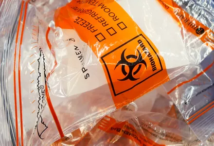 Discarded biohazard bags fill a trash can near a registration table for COVID-19 collection vials at Genetworx Clinical Lab in Richmond, Virginia, Friday April 24, 2020.